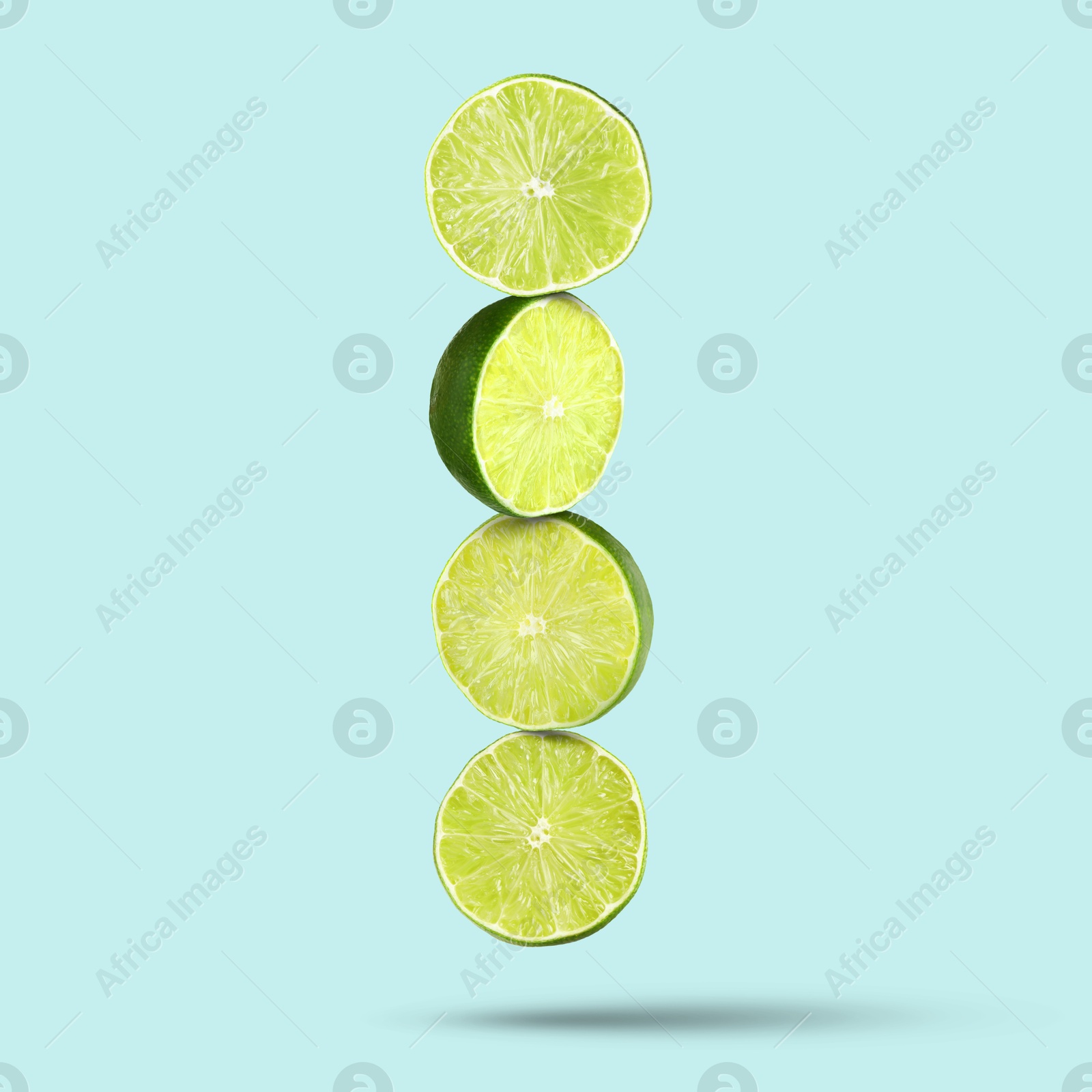 Image of Fresh lime slices falling on light blue background