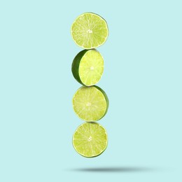 Image of Fresh lime slices falling on light blue background