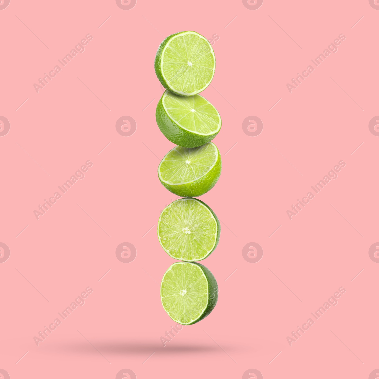 Image of Fresh lime slices falling on pink background