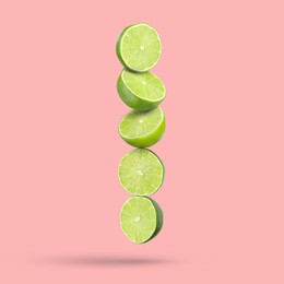 Image of Fresh lime slices falling on pink background