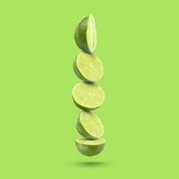 Image of Fresh lime slices falling on light green background