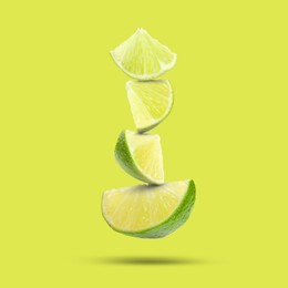 Image of Fresh lime slices falling on yellowish green background