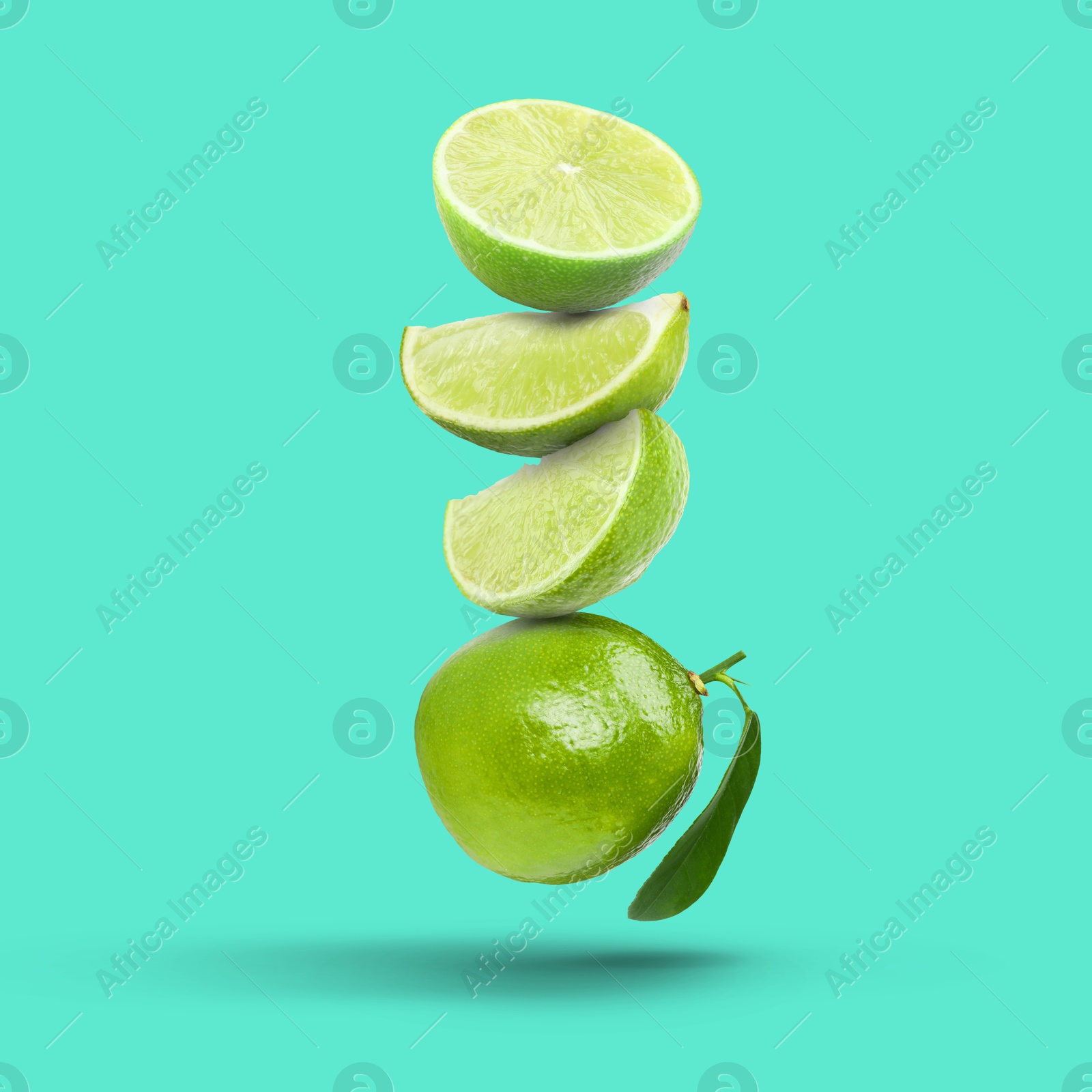 Image of Fresh juicy limes falling on turquoise background