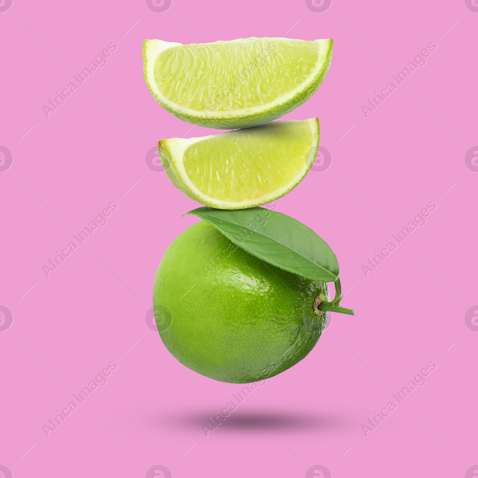 Image of Fresh juicy limes falling on fuchsia color background