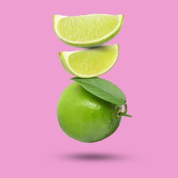 Image of Fresh juicy limes falling on fuchsia color background