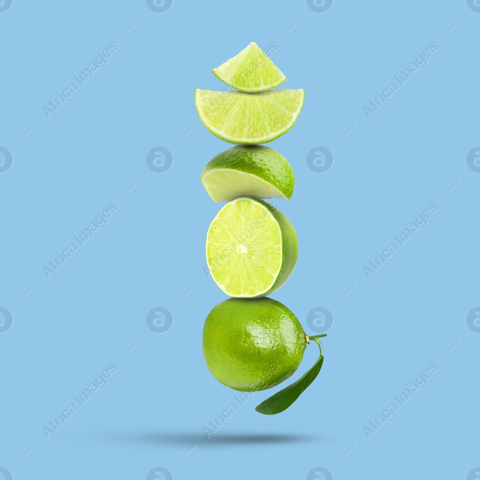 Image of Fresh juicy limes falling on light blue background