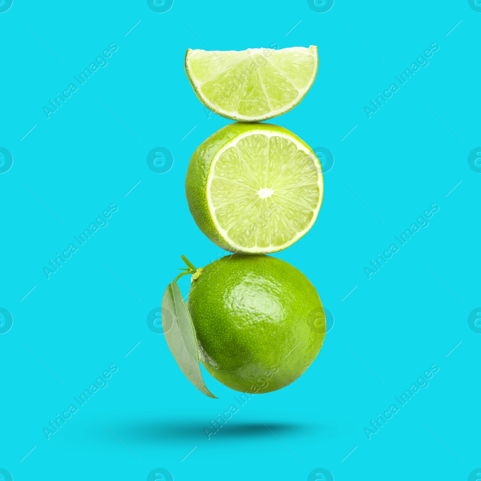 Image of Fresh juicy limes falling on light blue background