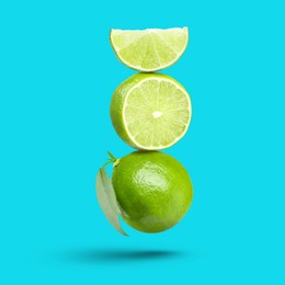 Image of Fresh juicy limes falling on light blue background