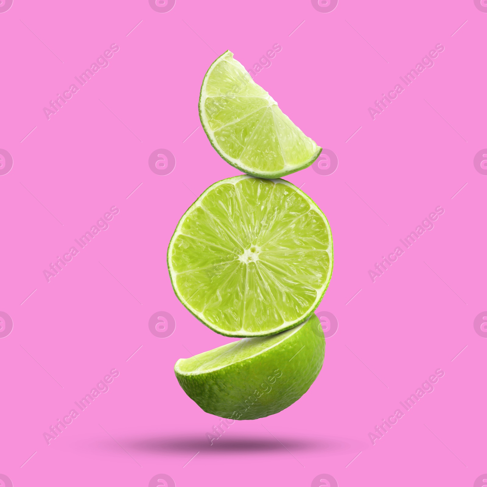 Image of Fresh lime slices falling on fuchsia color background