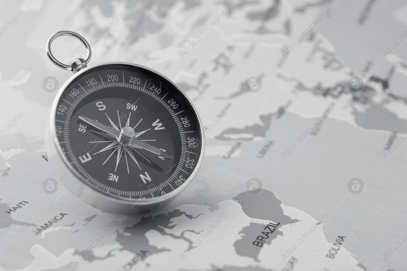 Image of Compass on world map, toned in black-and-white