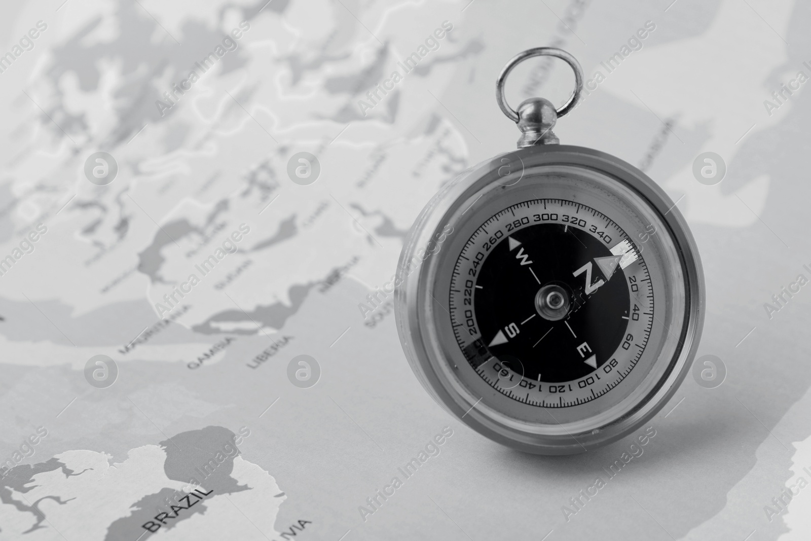 Image of Compass on world map, toned in black-and-white