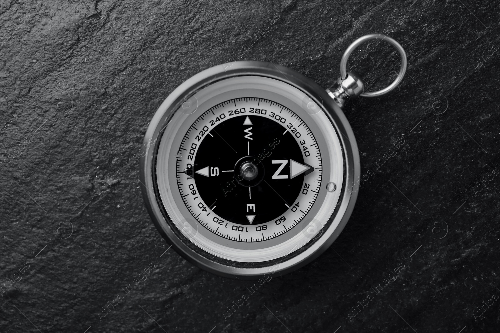 Image of Compass on textured table, top view. Toned in black-and-white