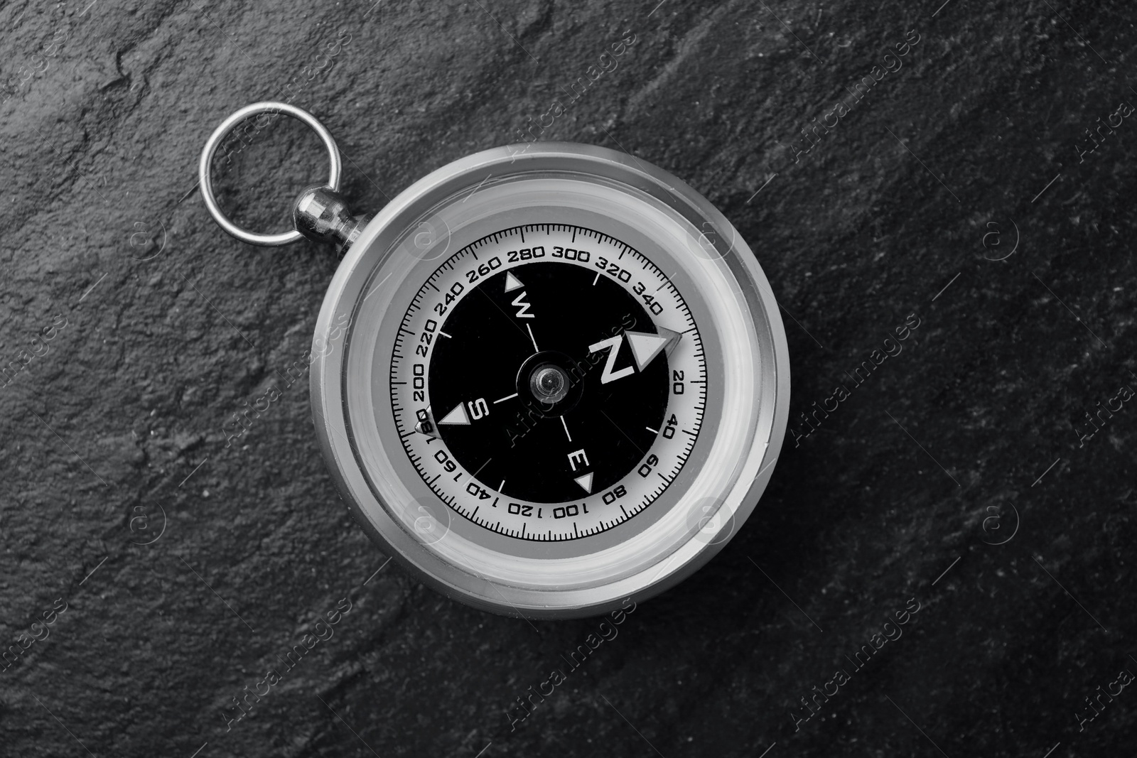 Image of Compass on textured table, top view. Toned in black-and-white