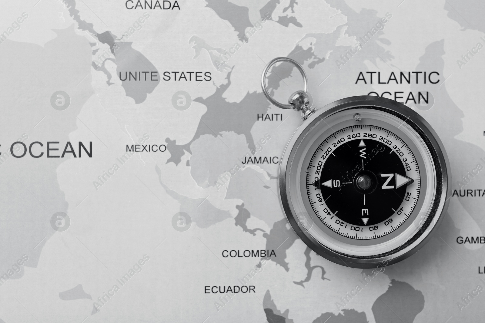 Image of Compass on world map, top view. Toned in black-and-white