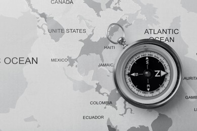 Image of Compass on world map, top view. Toned in black-and-white