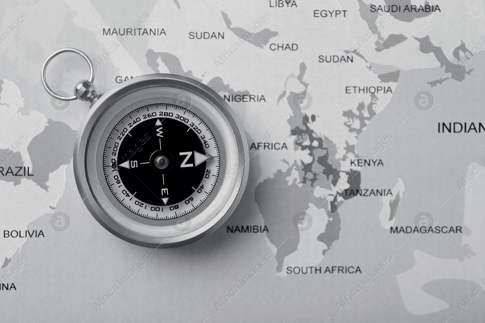 Image of Compass on world map, top view. Toned in black-and-white