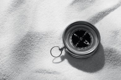 Image of Compass on sand, space for text. Toned in black-and-white