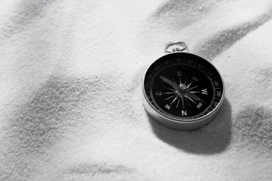 Image of Compass on sand, space for text. Toned in black-and-white