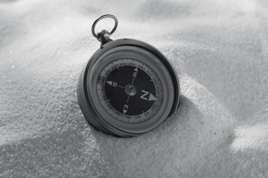 Image of Compass in sand, closeup. Toned in black-and-white