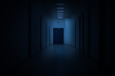 Image of Dark empty corridor in hospital or office building at night