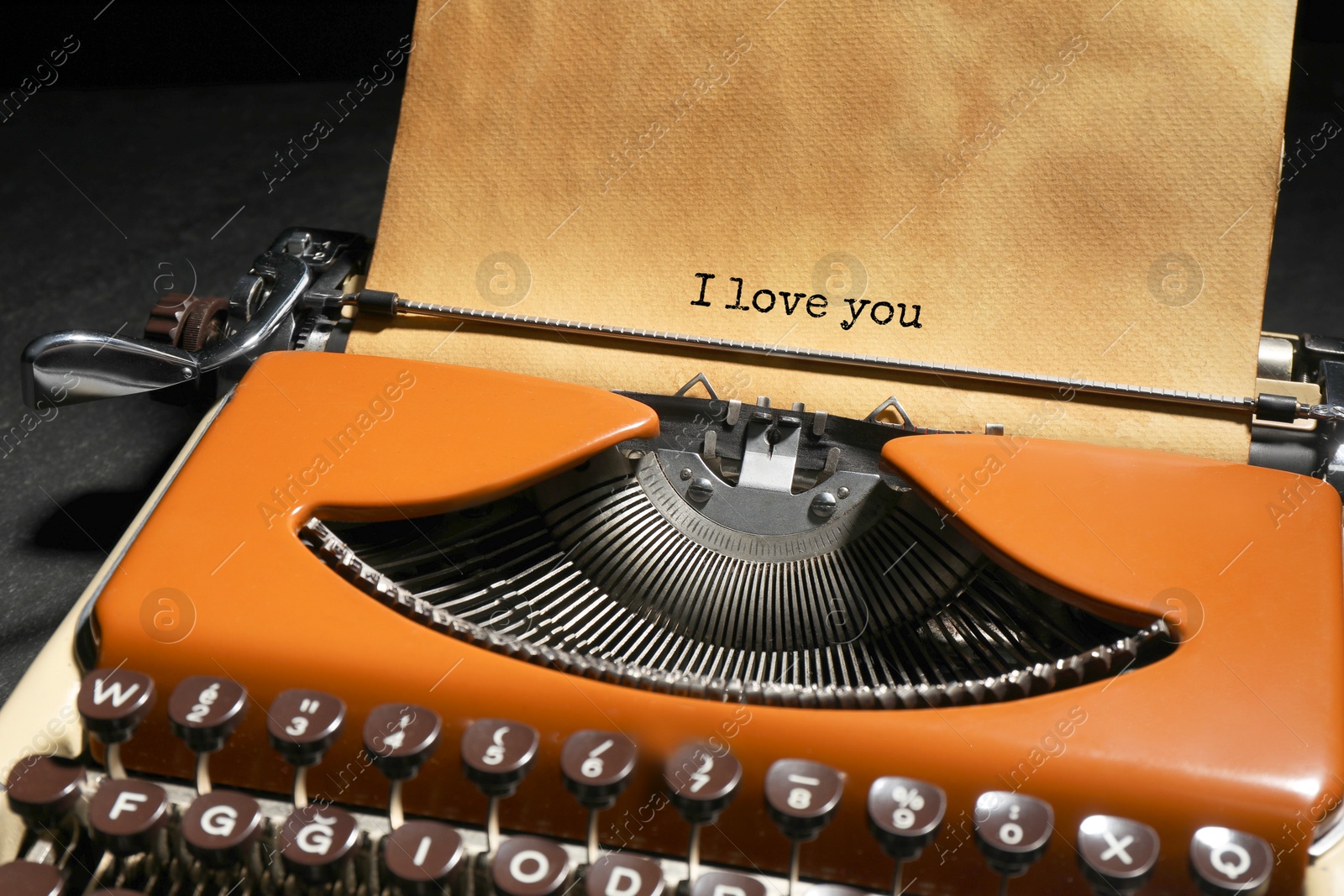 Image of Typewriter with sheet of paper on table, closeup. Typed text I Love You