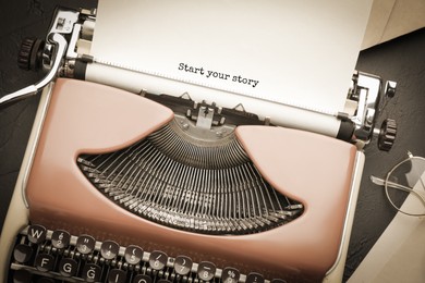 Typewriter with sheet of paper on table, top view. Typed text Start Your Story