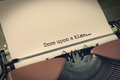 Image of Typewriter with sheet of paper, closeup. Typed text Once Upon A Time