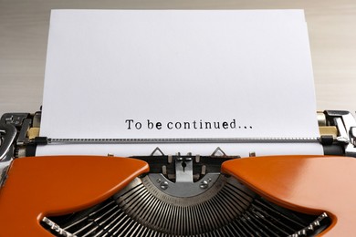 Image of Typewriter with sheet of paper, closeup. Typed text To Be Continued