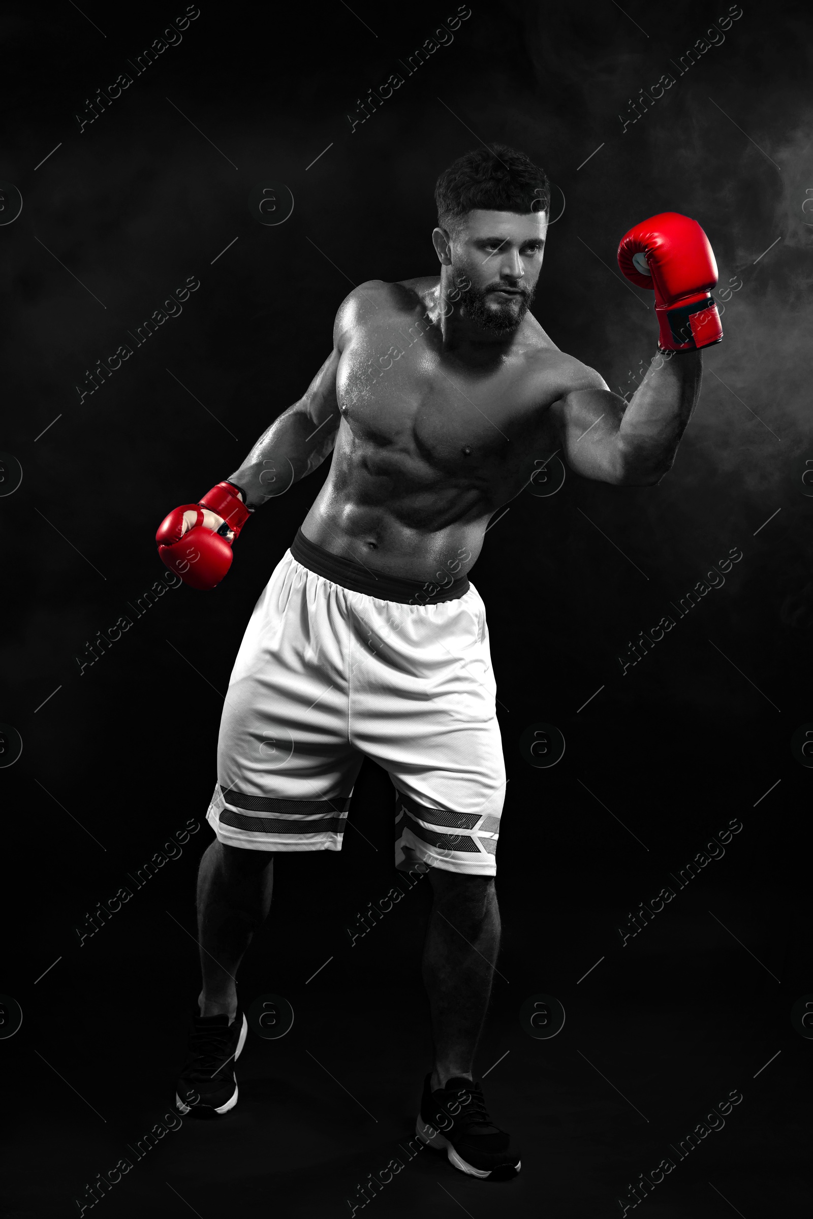 Image of Man in boxing gloves fighting, black-and-white toning with color accent