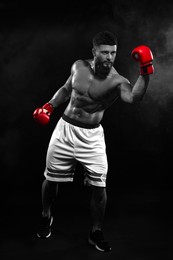 Image of Man in boxing gloves fighting, black-and-white toning with color accent