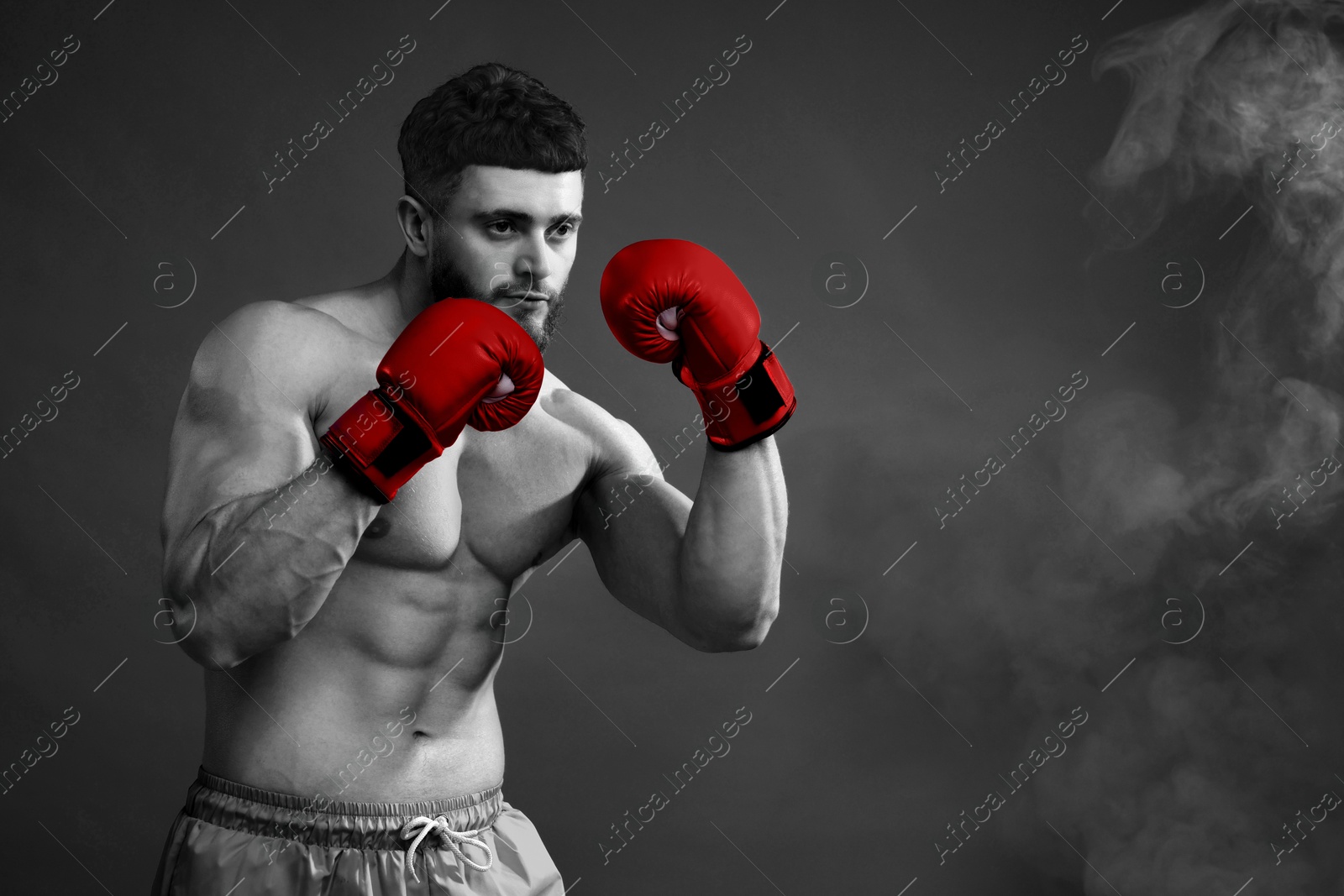 Image of Man in boxing gloves fighting, black-and-white toning with color accent. Space for text