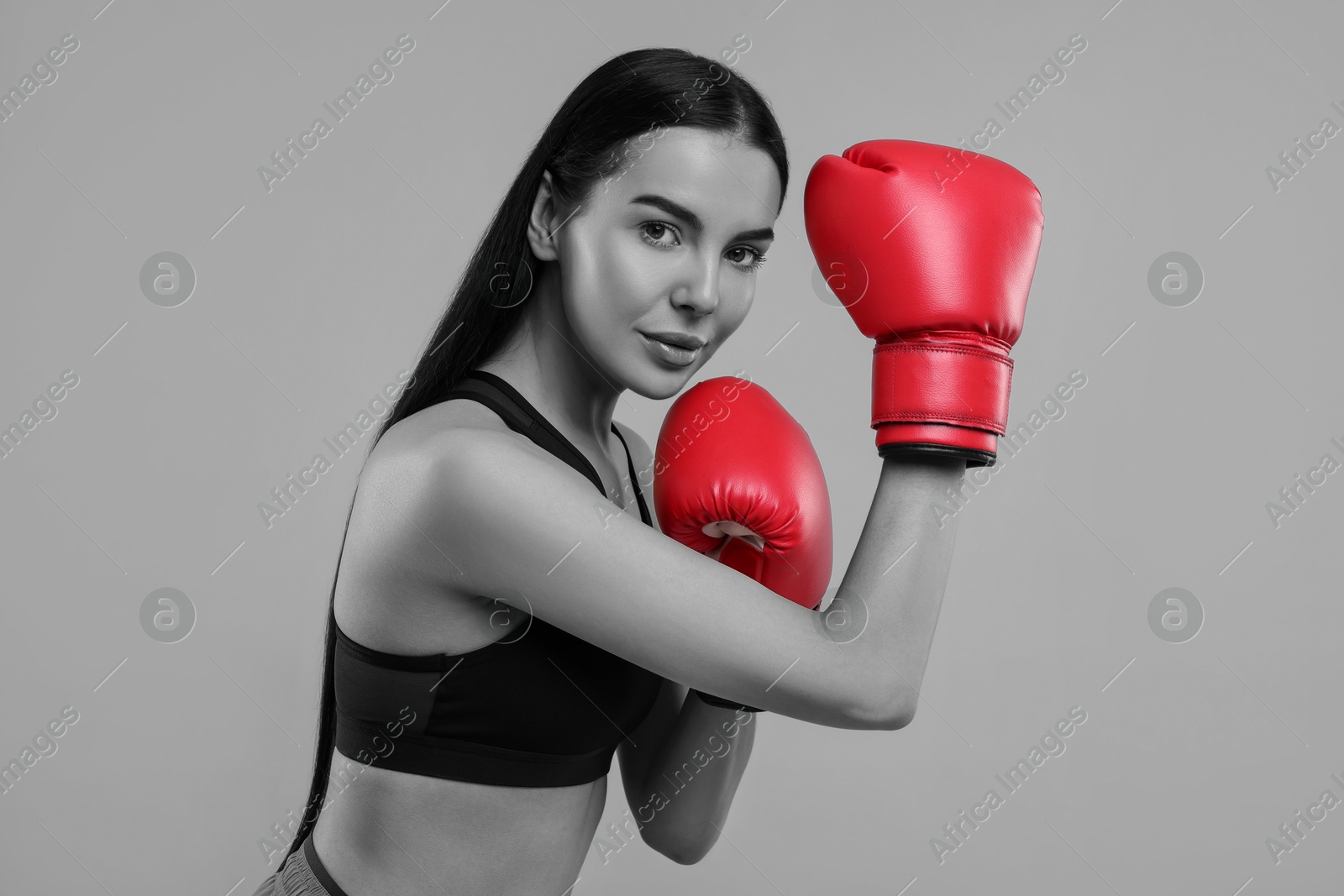 Image of Beautiful woman in boxing gloves, black-and-white toning with color accent