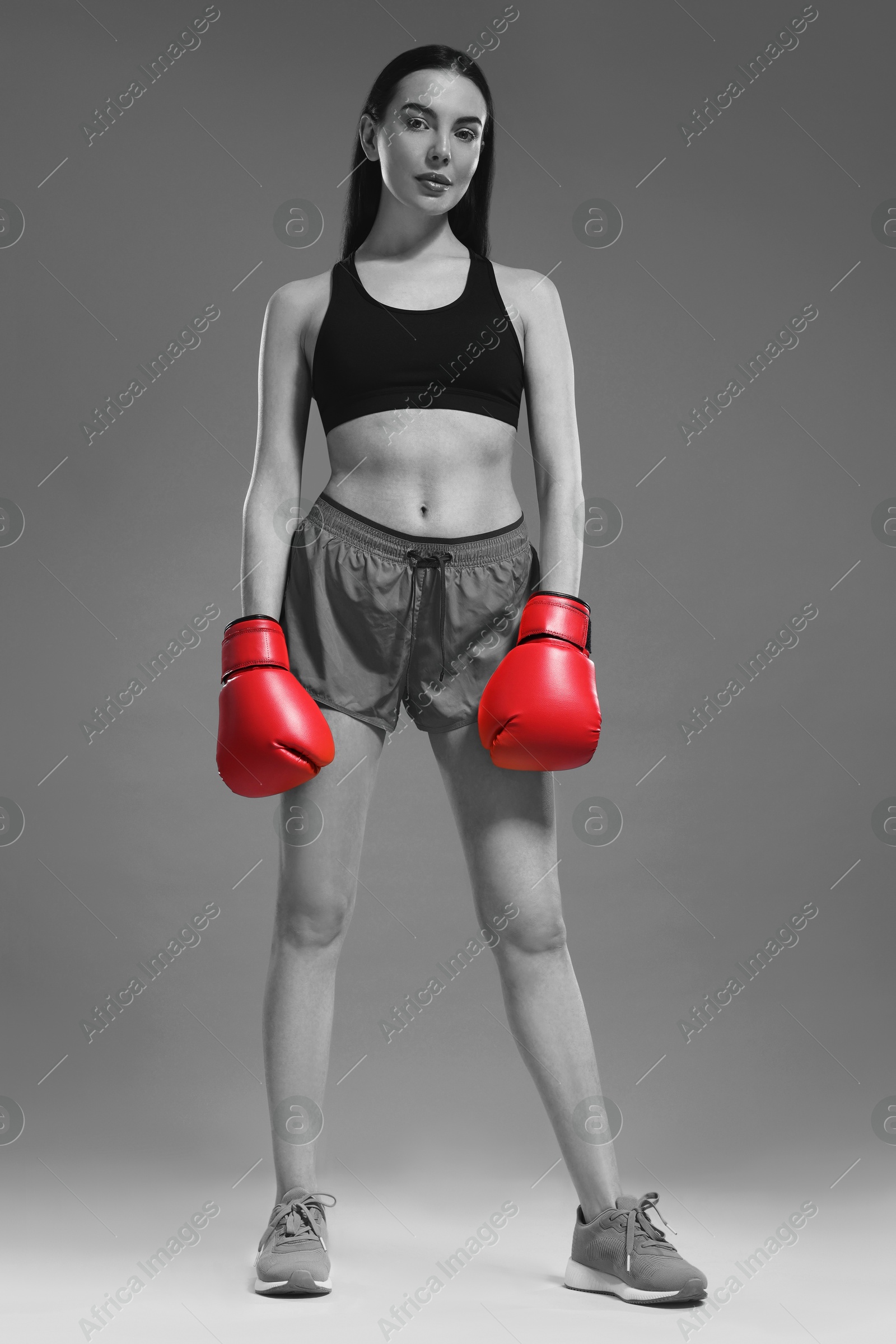 Image of Beautiful woman in boxing gloves, black-and-white toning with color accent