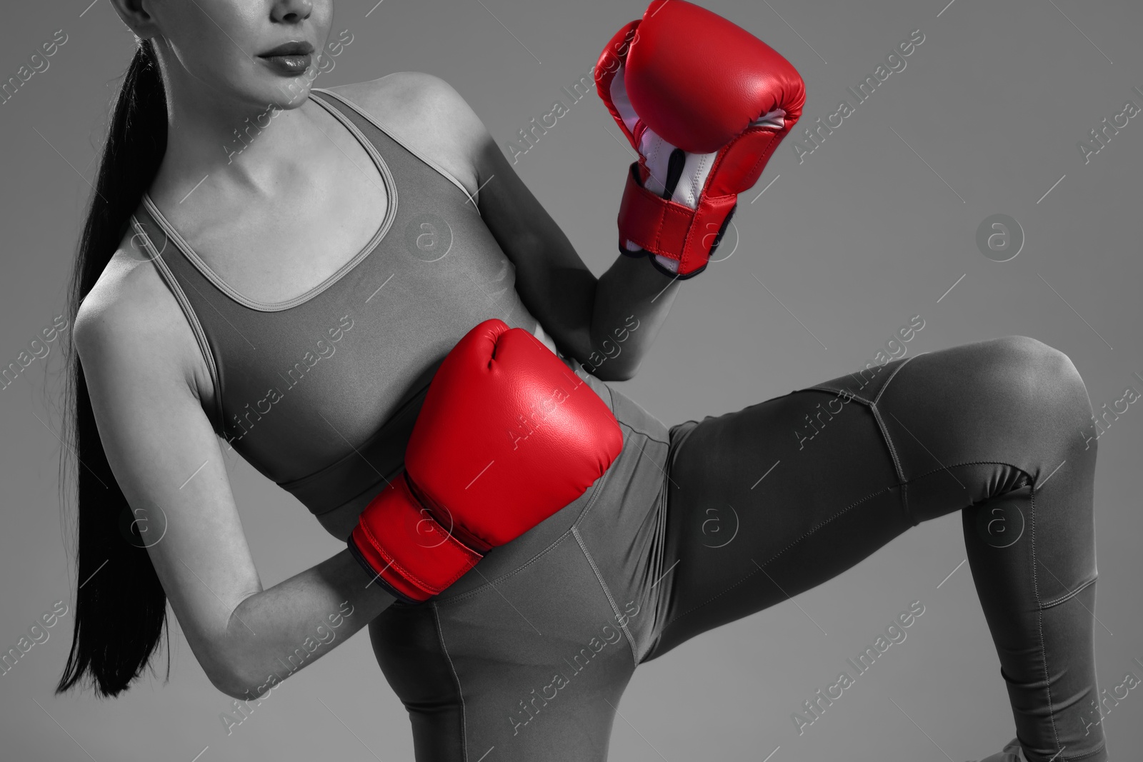 Image of Woman in boxing gloves, closeup. Black-and-white toning with color accent