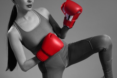 Image of Woman in boxing gloves, closeup. Black-and-white toning with color accent