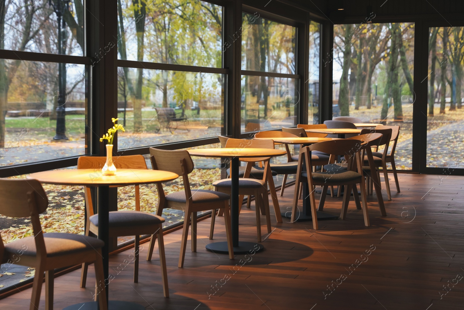 Photo of Stylish restaurant with large windows and comfortable furniture. Interior design