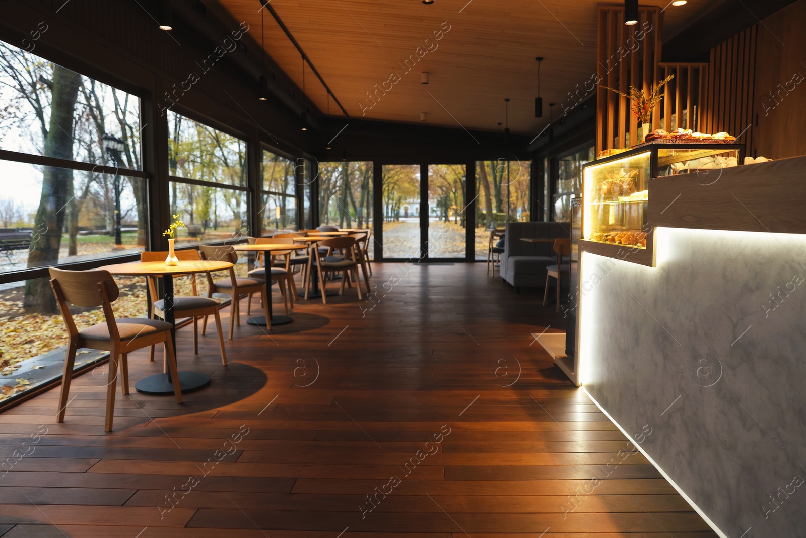 Photo of Stylish restaurant with large windows and comfortable furniture. Interior design