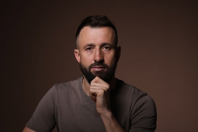 Photo of Portrait of handsome bearded man on brown background