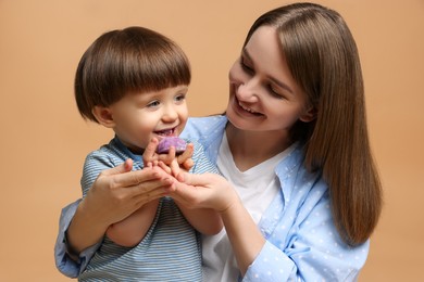 Photo of Mother and baby eating tasty mochi on brown background