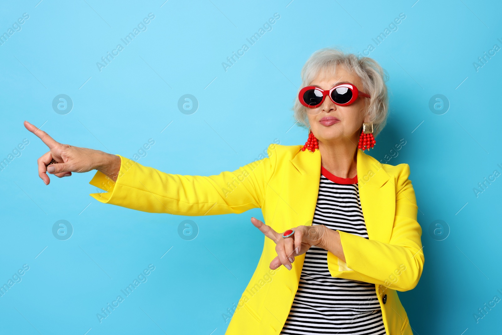 Photo of Portrait of cool grandmother on light blue background