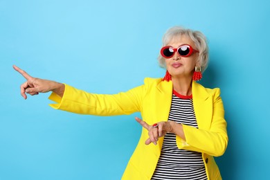 Photo of Portrait of cool grandmother on light blue background