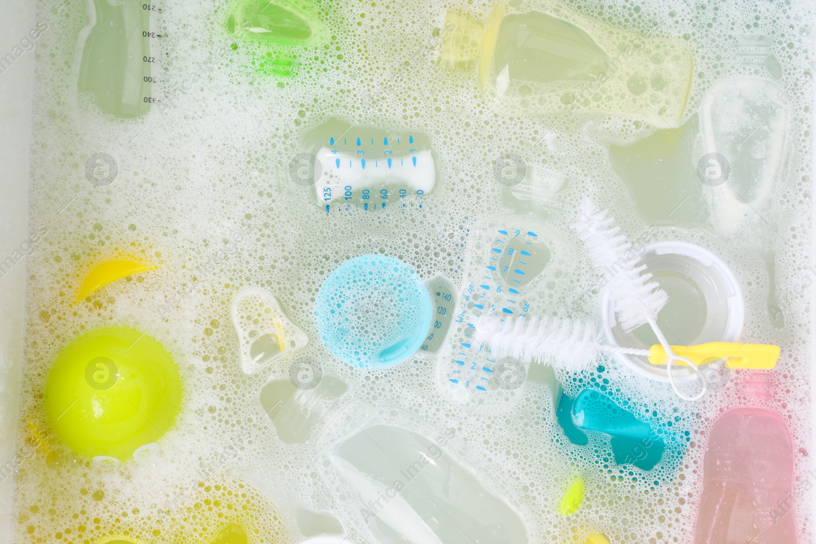 Photo of Washing feeding bottles in sink, top view