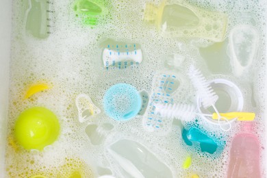 Photo of Washing feeding bottles in sink, top view