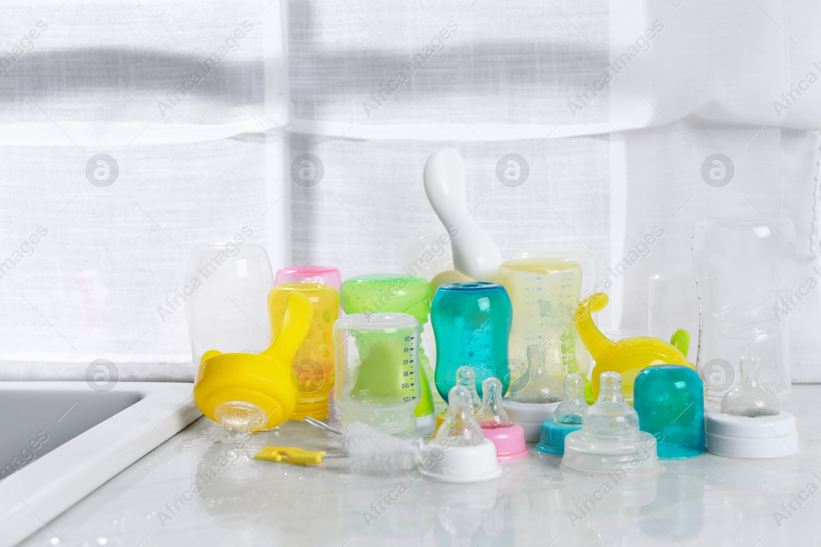 Photo of Clean feeding bottles drying on counter indoors