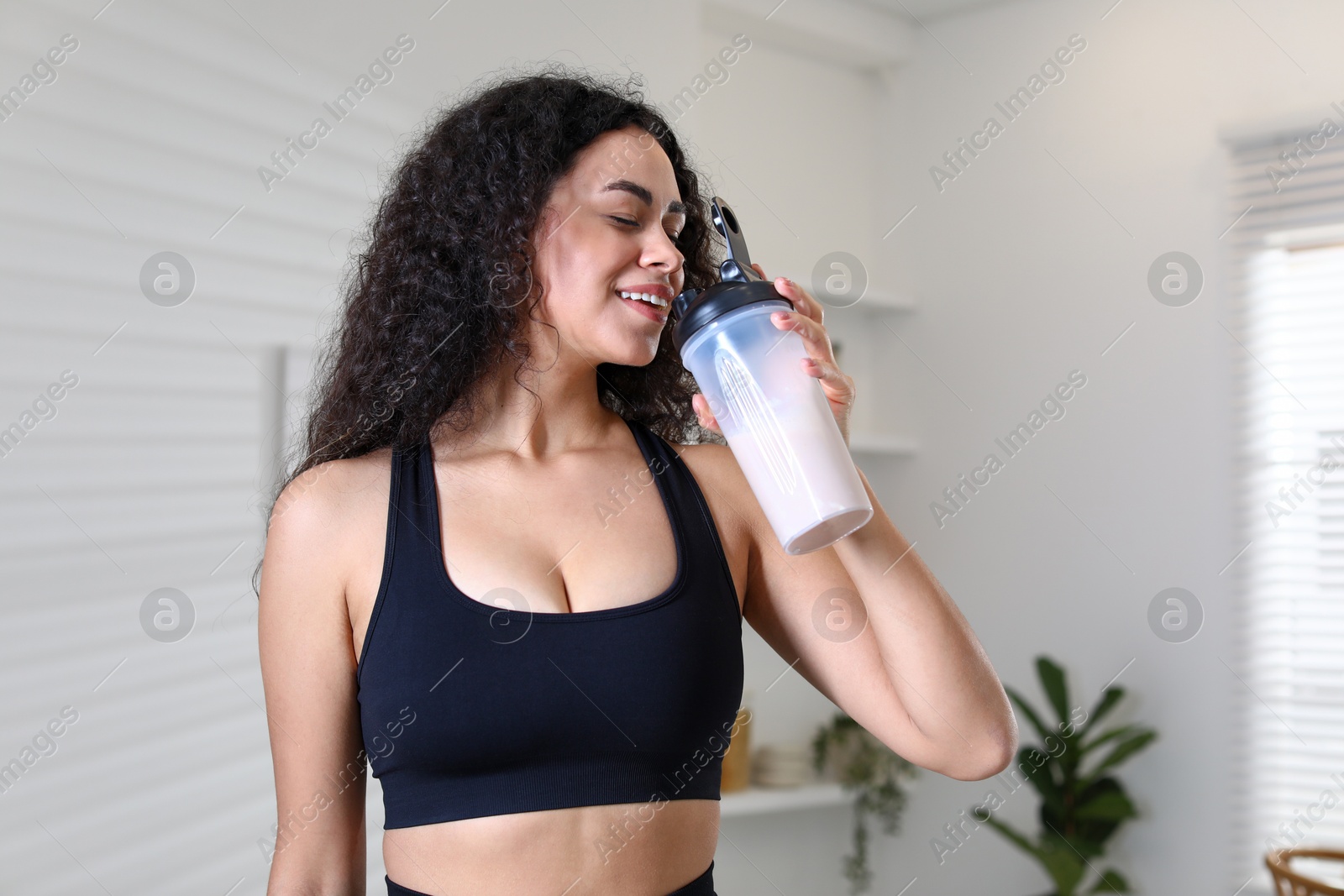 Photo of Beautiful woman drinking protein shake at home