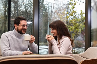 Happy colleagues having coffee break in cafe