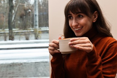 Photo of Smiling woman having coffee break in cafe. Space for text