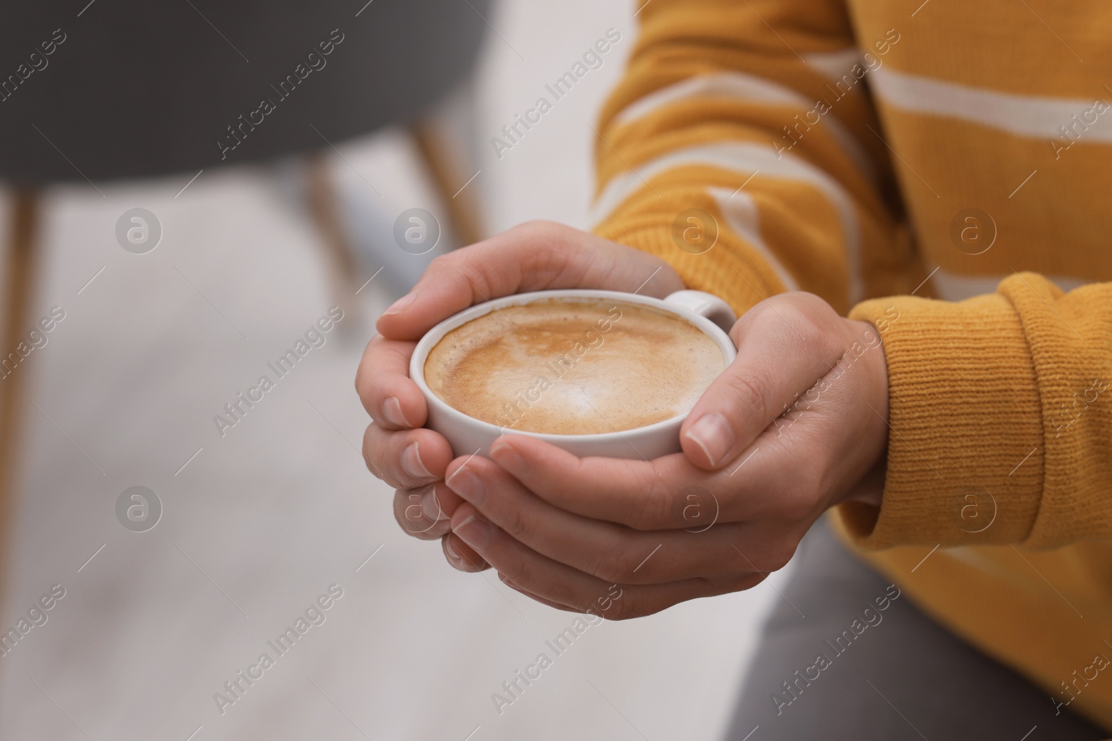 Photo of Coffee break. Woman with cup of hot drink indoors, closeup