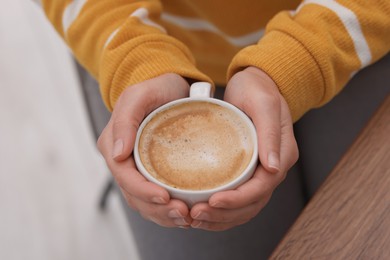 Photo of Coffee break. Woman with cup of hot drink indoors, closeup