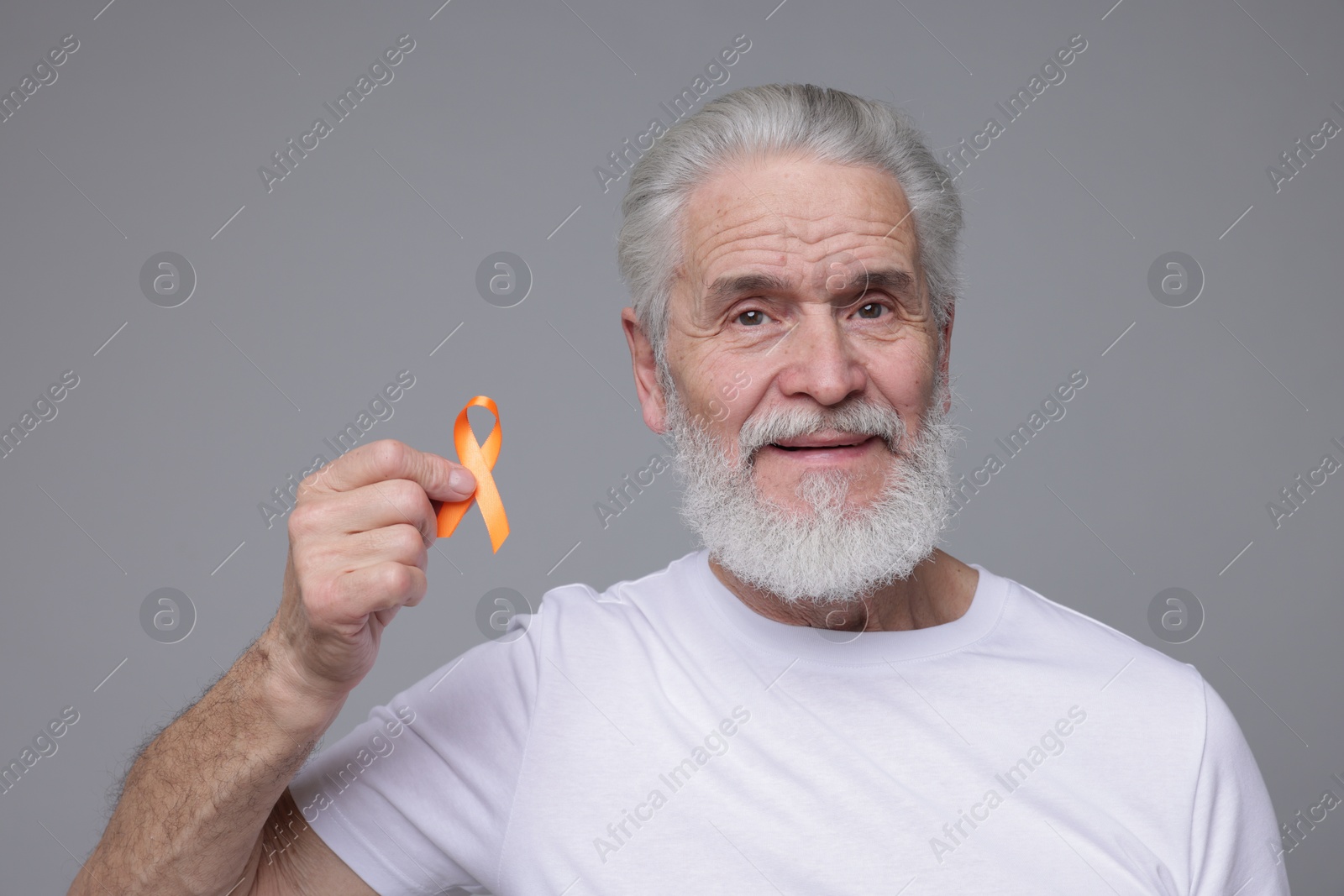 Photo of Multiple Sclerosis awareness. Senior man with orange ribbon on grey background